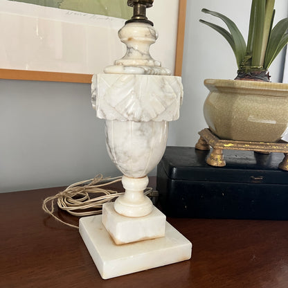 Marble lamp on a wooden surface with a plant in the background
