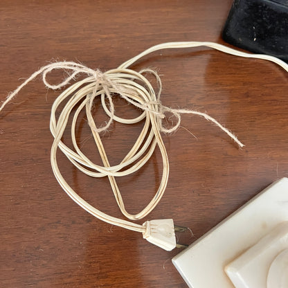Coiled beige cable with a plug on a wooden surface