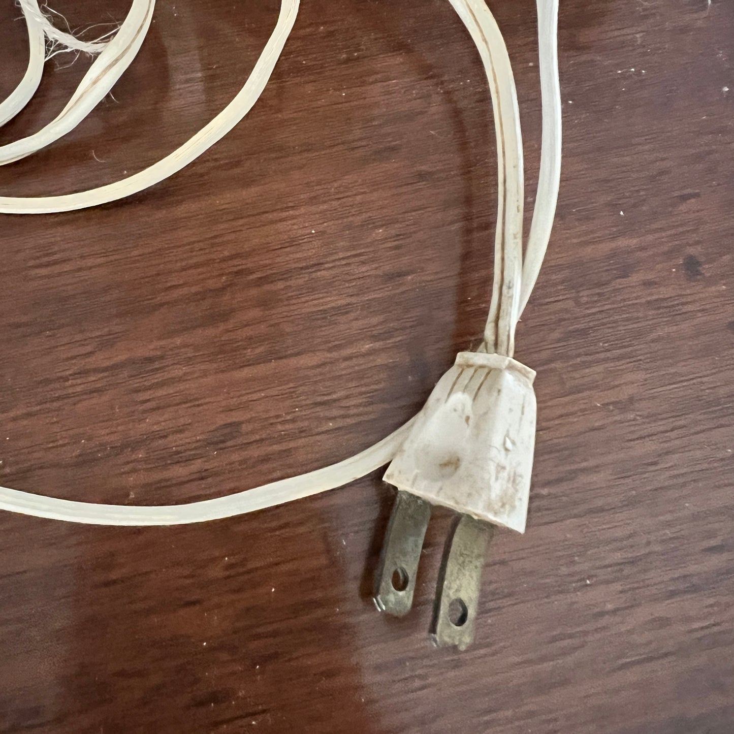 Old electrical plug with a coiled cable on a wooden surface