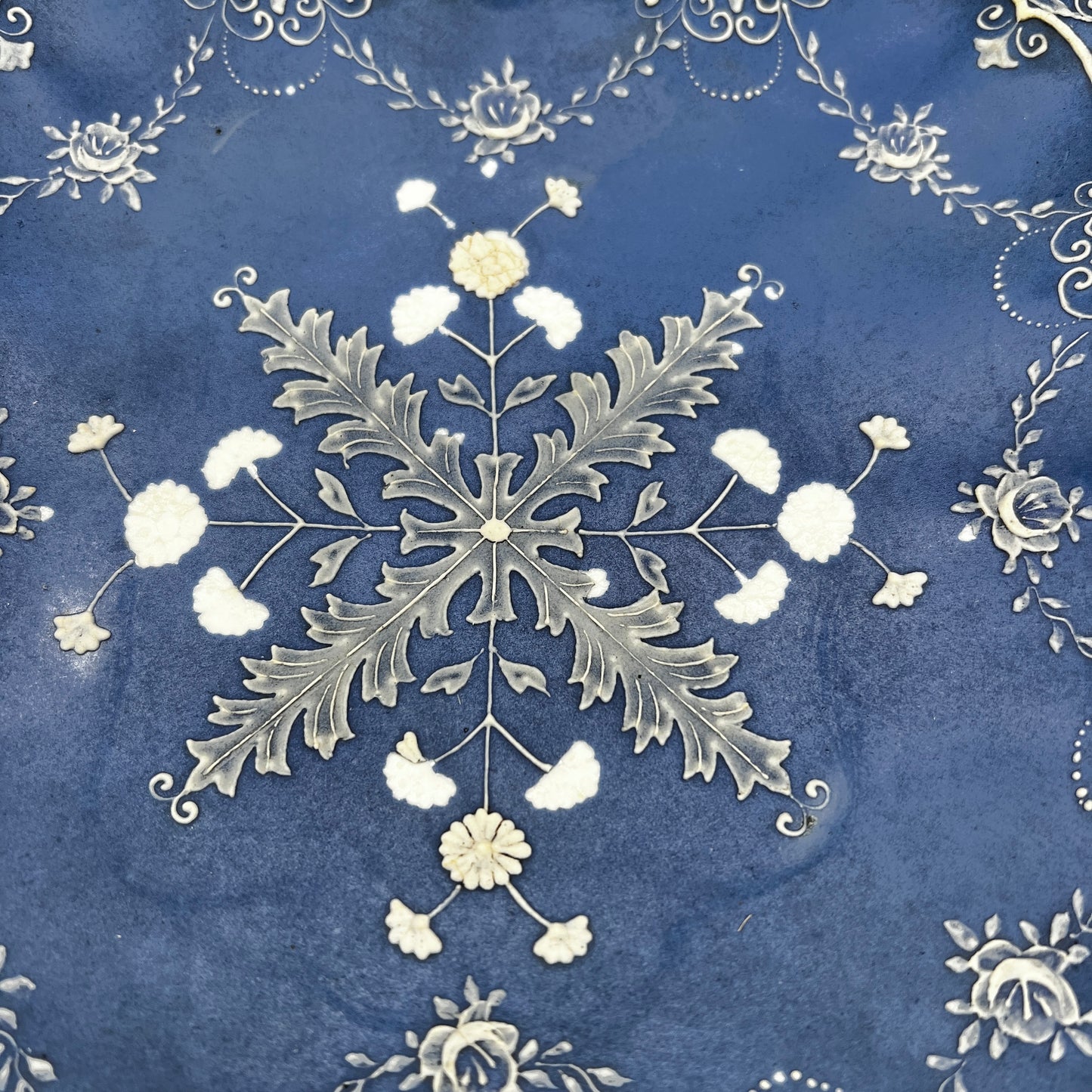 Decorative snowflake design on a blue background with floral elements.