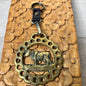 Brass keychain with cow design on a wooden surface