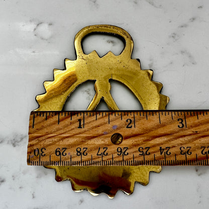 Measurement Vintage Masonic square and compass brass medallion on white marble surface