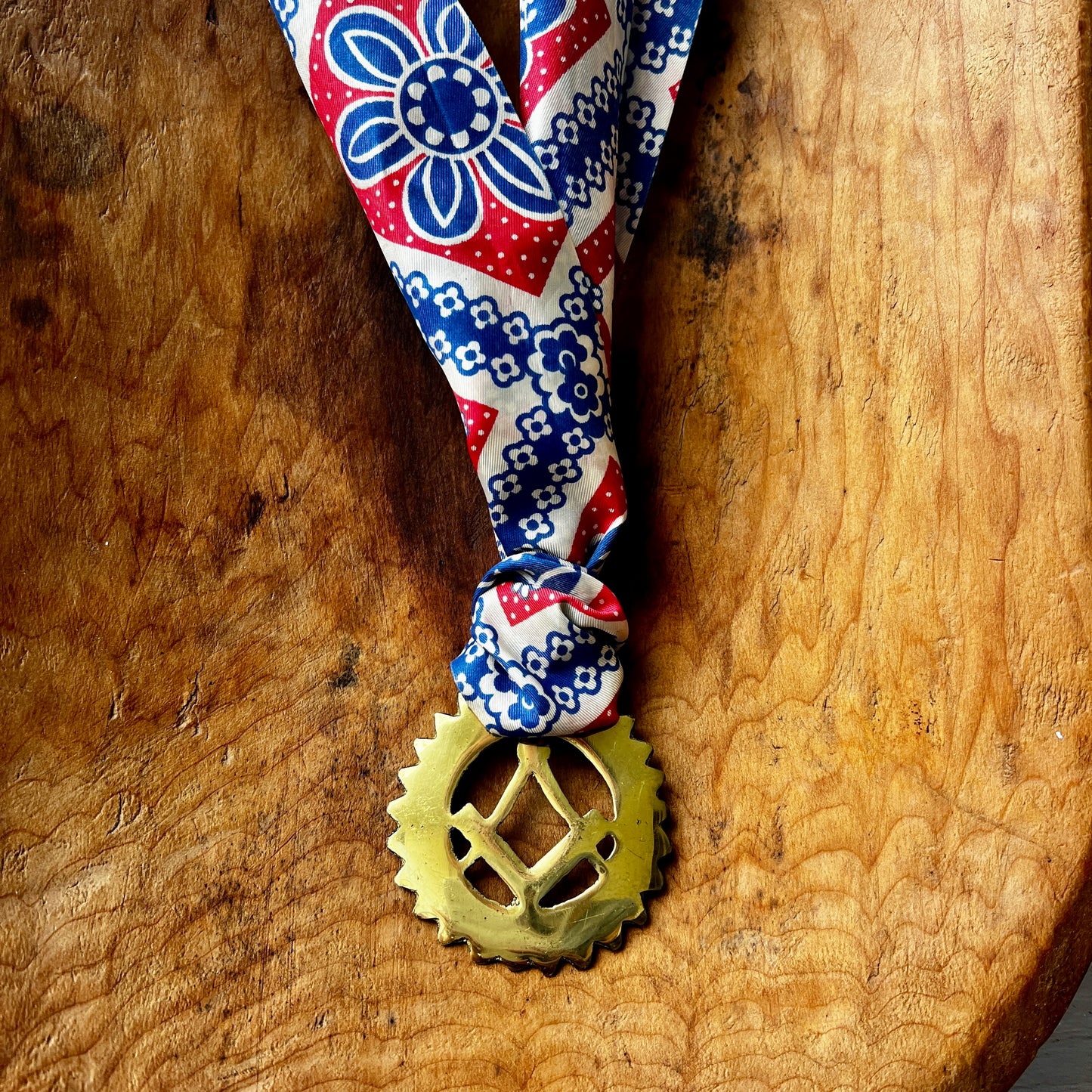 Vintage Masonic square and compass brass medallion necklace with red white blue scarf on wood background