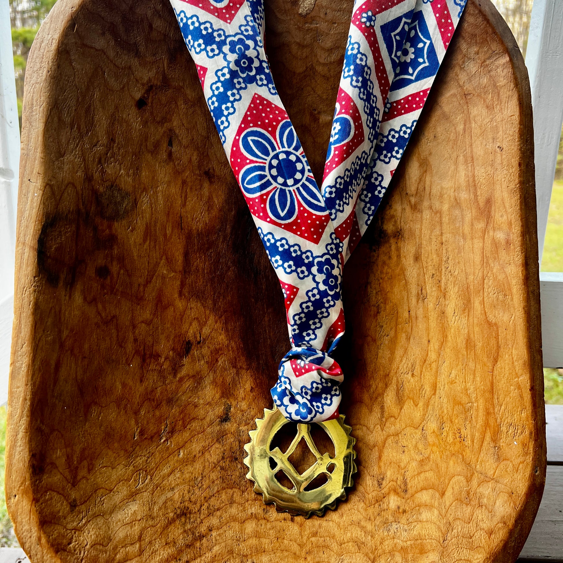 Decorative necklace with a masonic charm on a wooden surface