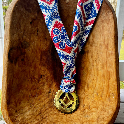 Decorative necklace with a masonic charm on a wooden surface