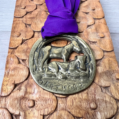 Medal with purple ribbon on a wooden surface