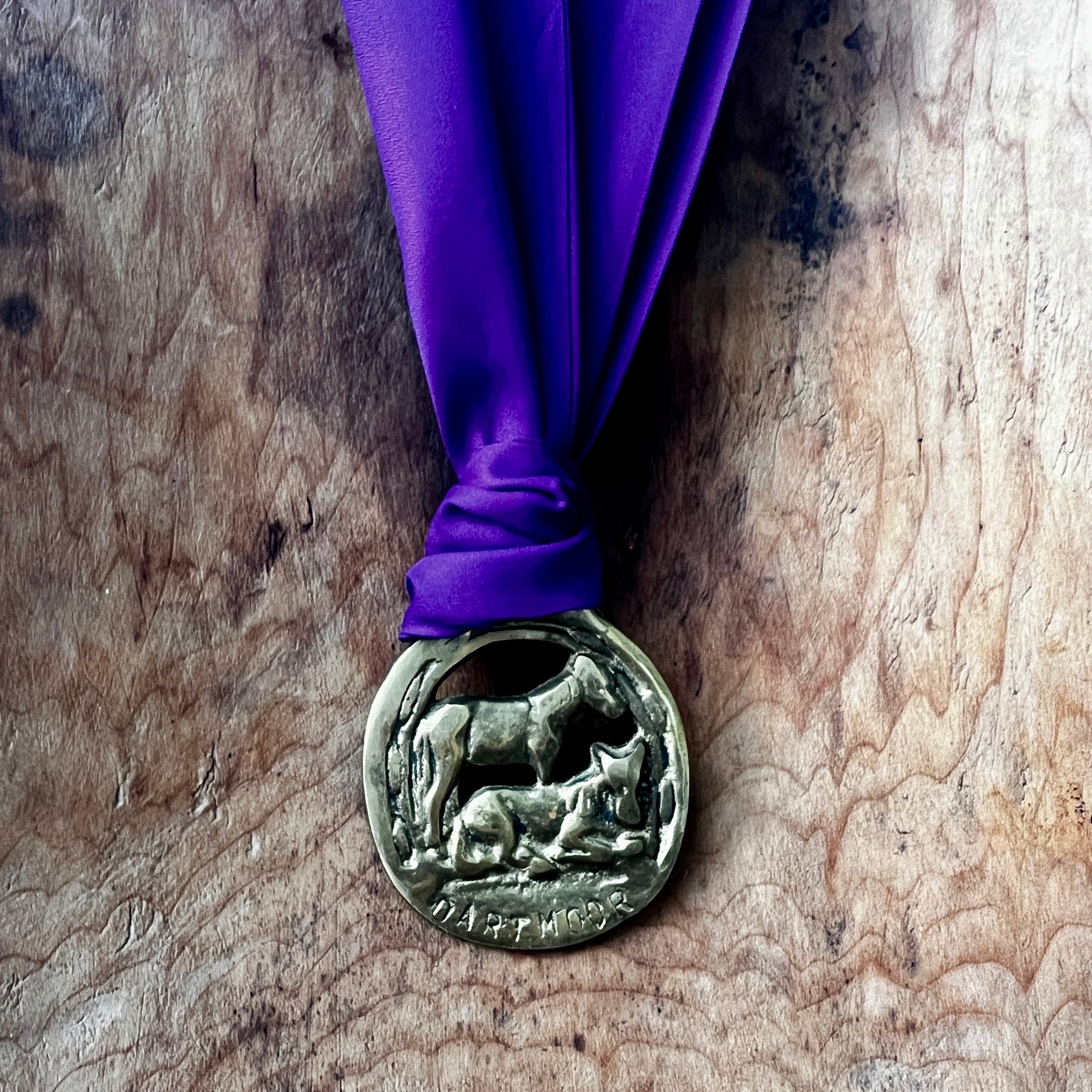 Medal with purple ribbon on a wooden surface
