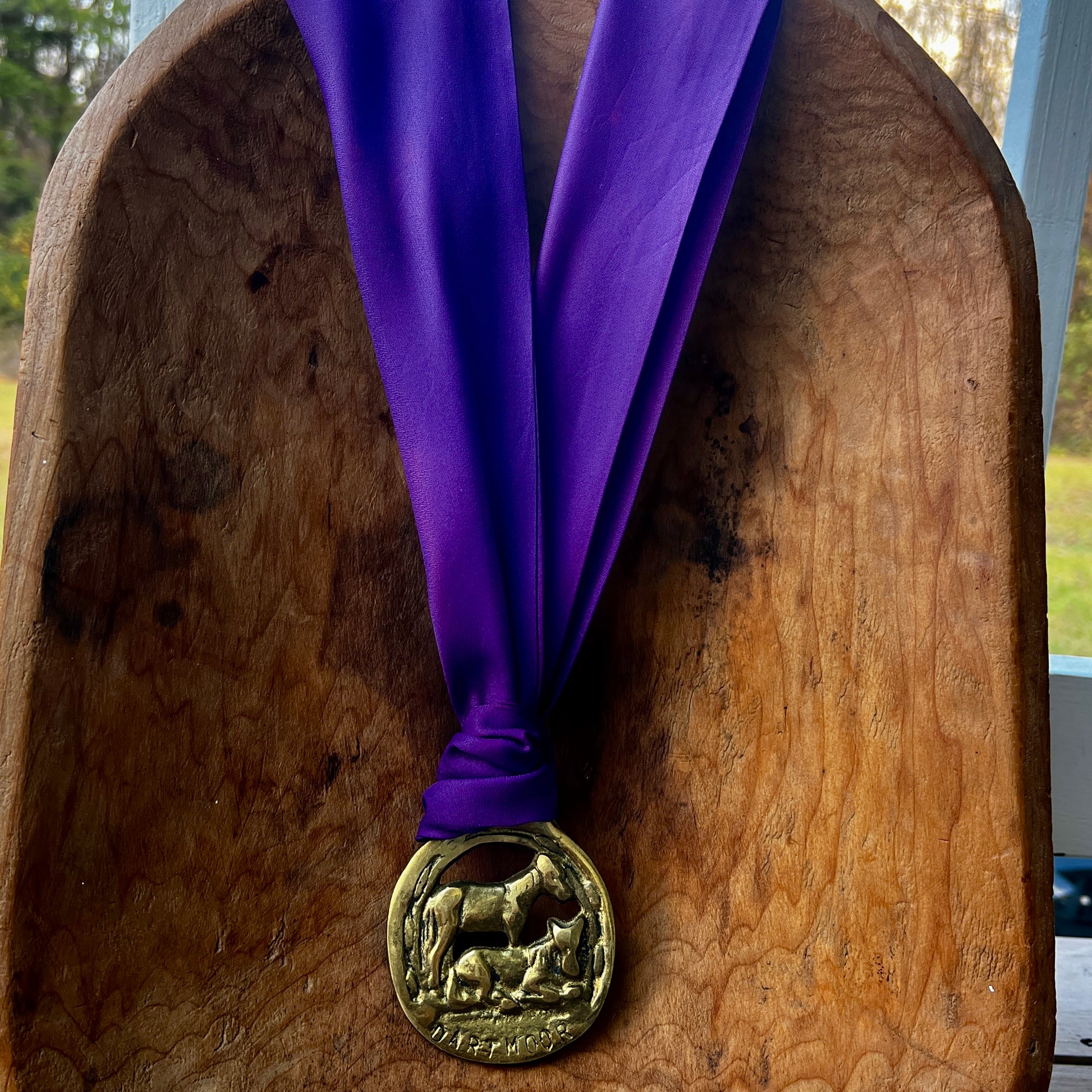 Medal with purple ribbon on a wooden surface