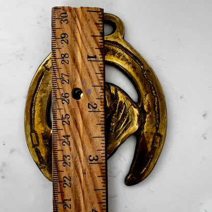 Vintage horse brass medallion attached to multi-strand wooden bead necklace with caramel leather connector.