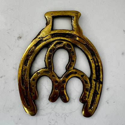Vintage double horseshoe brass medallion necklace with dark multi-strand beads and leather connector.