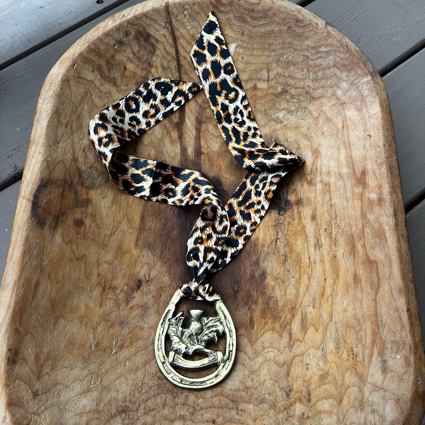 Vintage brass Scottish thistle medallion necklace with leopard-print scarf, rustic boho jewelry.