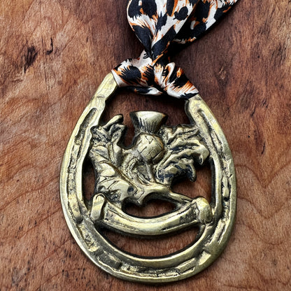 Vintage brass Scottish thistle medallion necklace with leopard-print scarf, rustic boho jewelry.