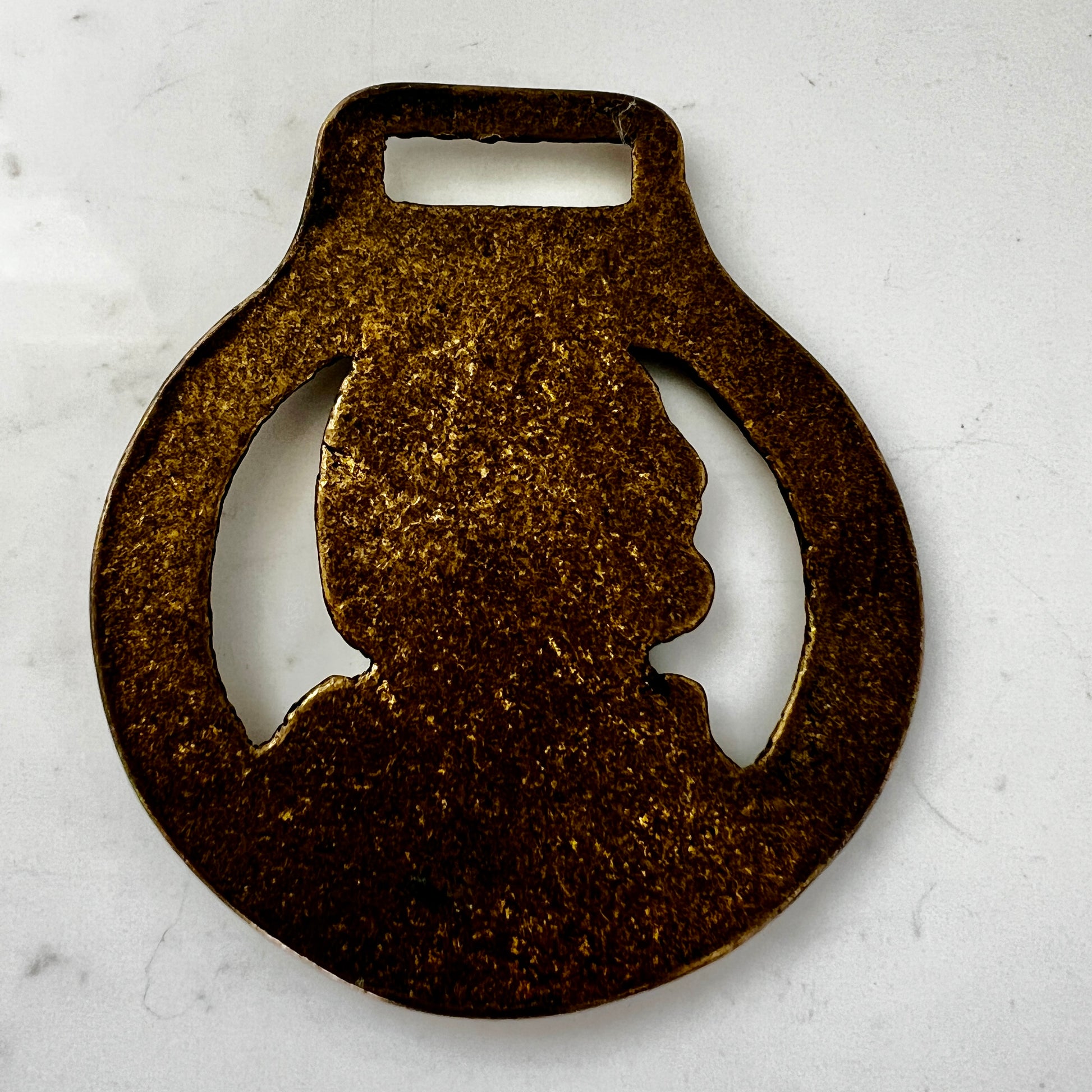 Vintage William Shakespeare horse brass medallion attached to brown leather keychain with brass ring and clip.