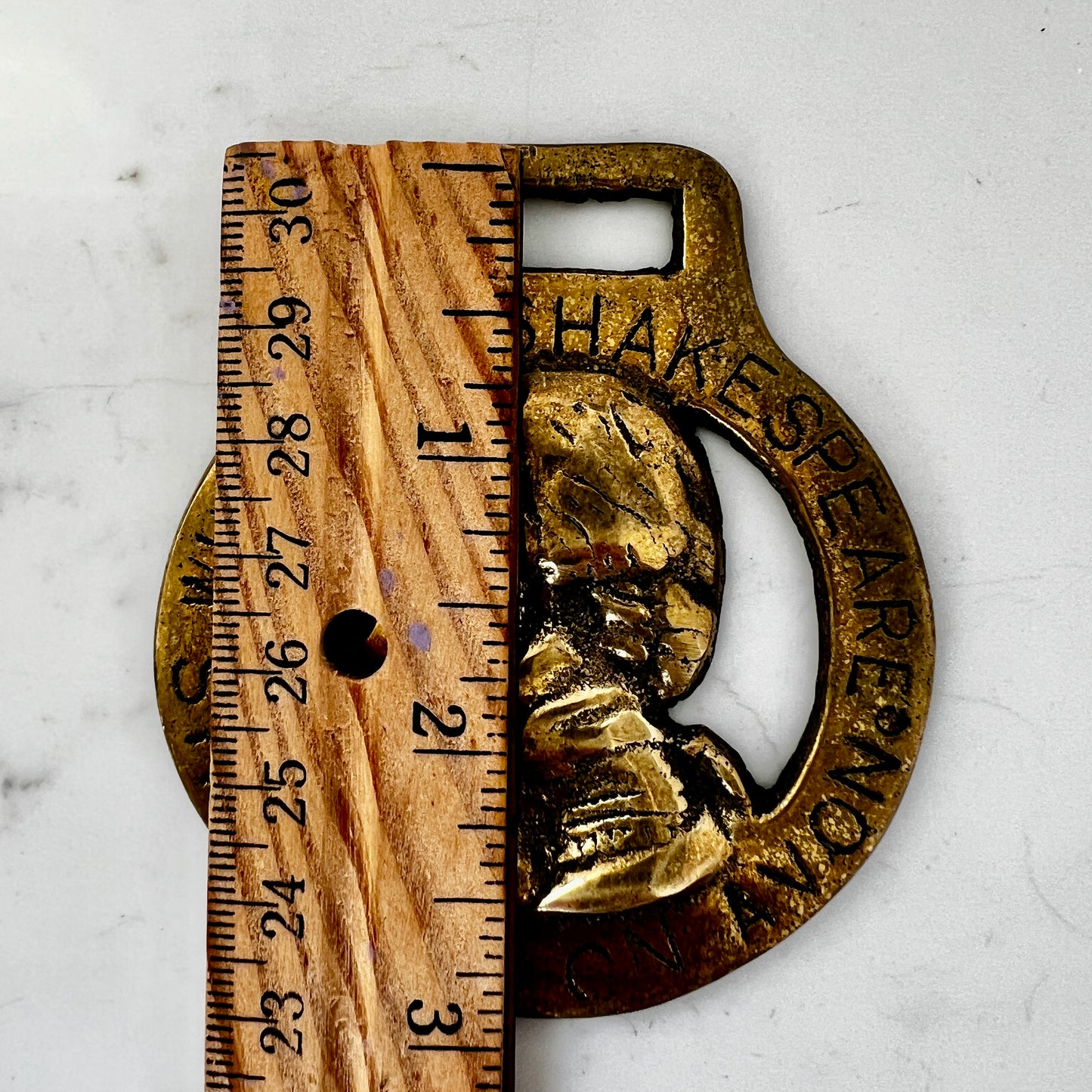 Vintage William Shakespeare horse brass medallion attached to brown leather keychain with brass ring and clip.