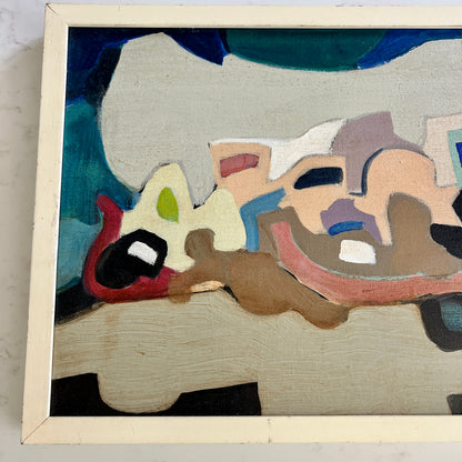 A framed abstract painting featuring organic shapes in beige, brown, red, blue, green, and black, housed in a light cream-colored wooden frame.