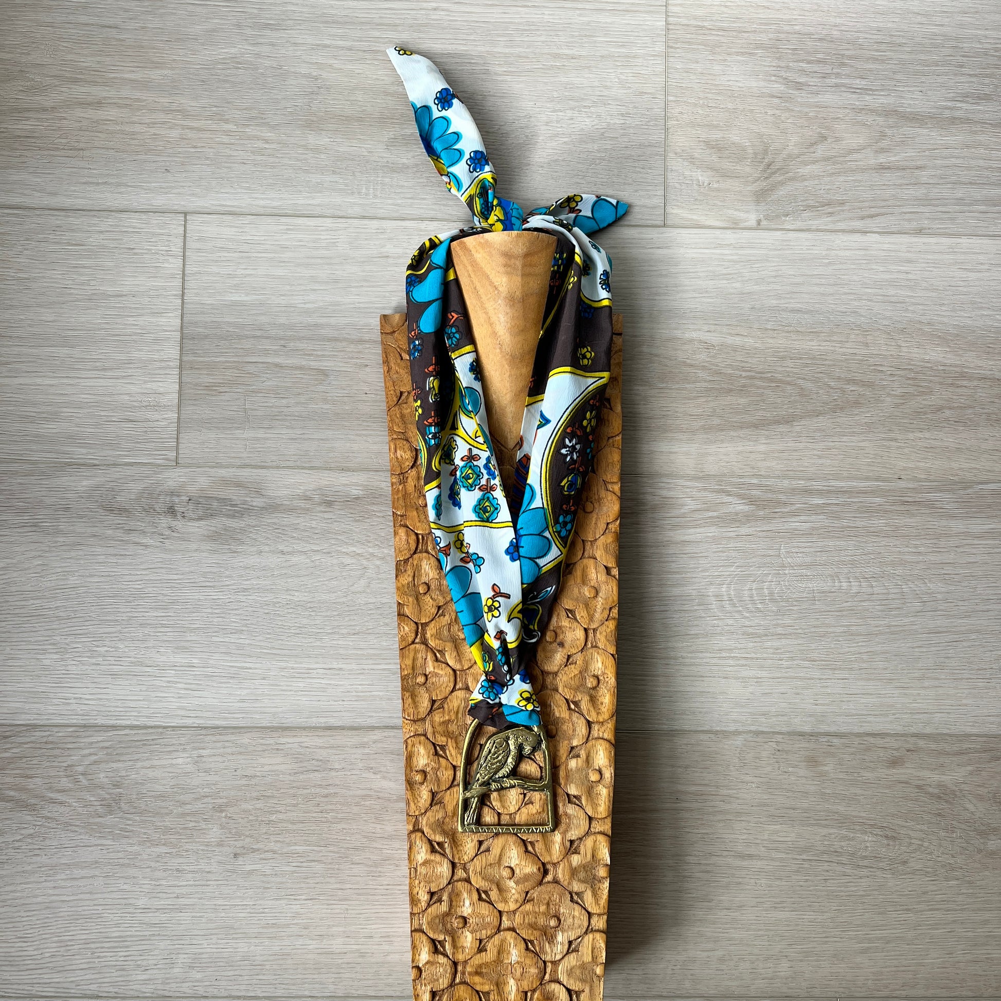 a patterned scarf on a wooden surface