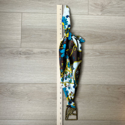 Decorative necklace with floral pattern next to a ruler on a wooden surface