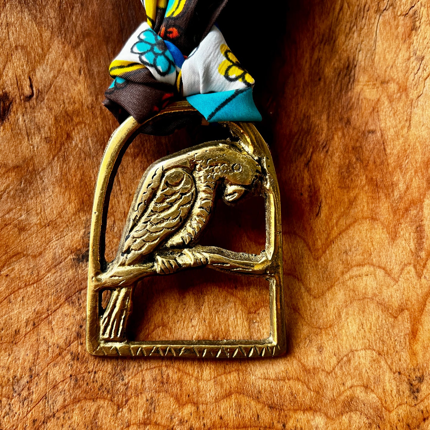Brass parrot-shaped medallion on a wooden surface
