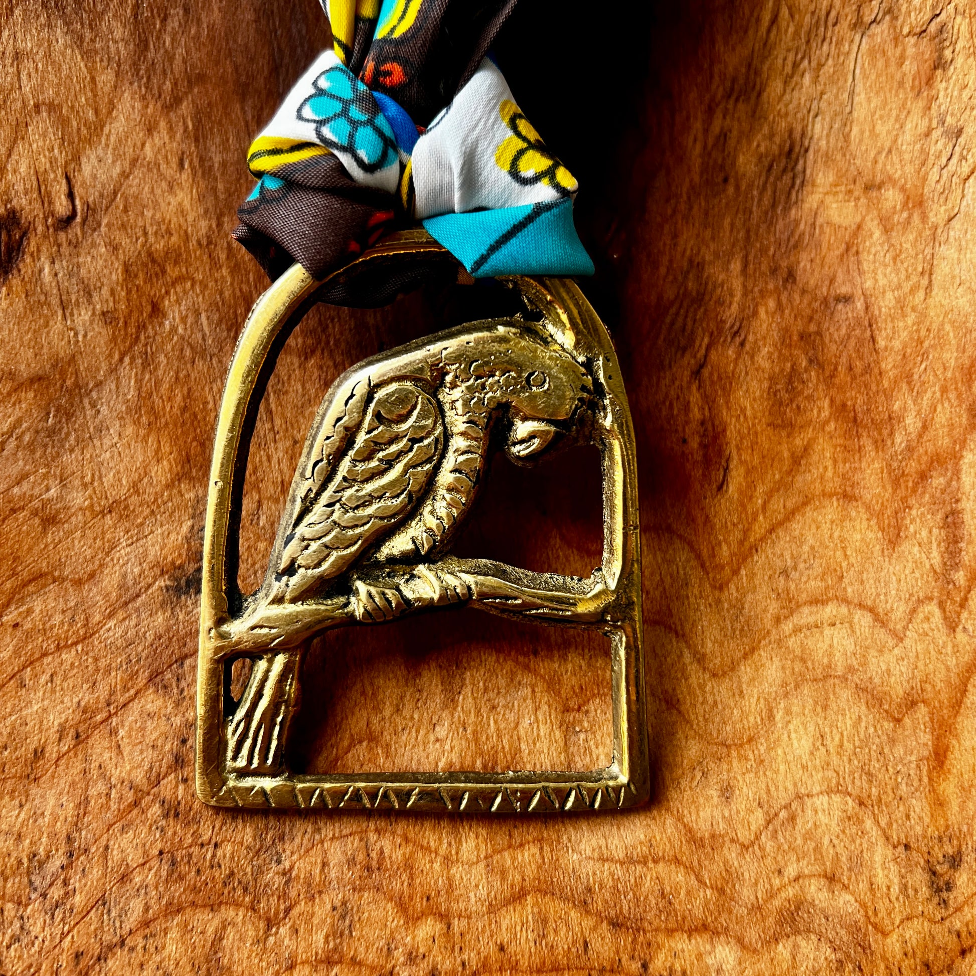 Brass parrot-shaped medallion on a wooden surface