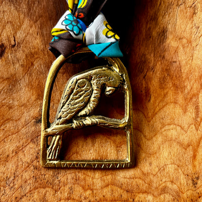 Brass parrot-shaped medallion on a wooden surface