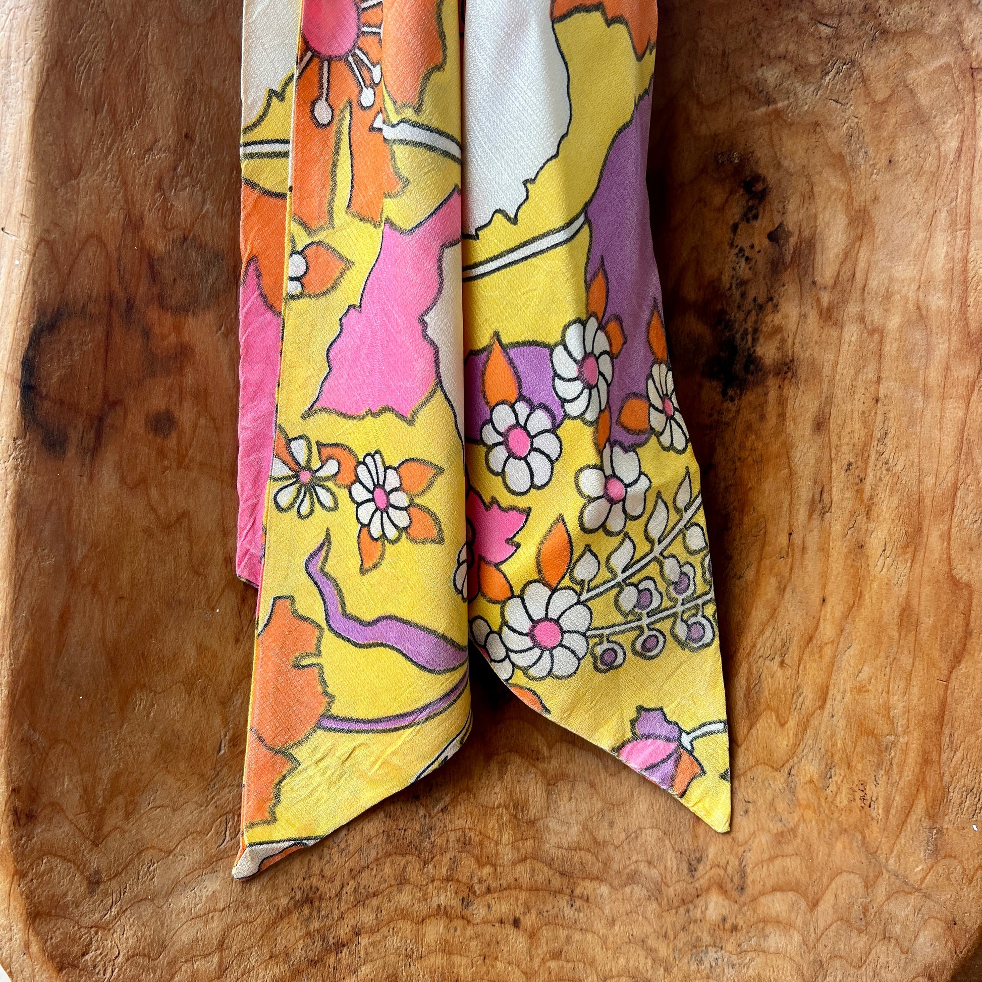 Colorful floral-patterned fabric folded and placed on a wooden surface