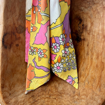 Colorful floral-patterned fabric folded and placed on a wooden surface