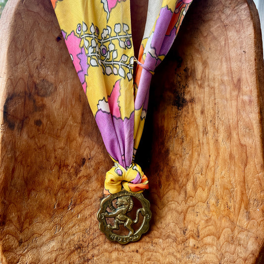 Colorful ribbon with a decorative lion medallion on a wooden surface