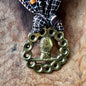 Decorative brass ornament with a bow on a wooden surface
