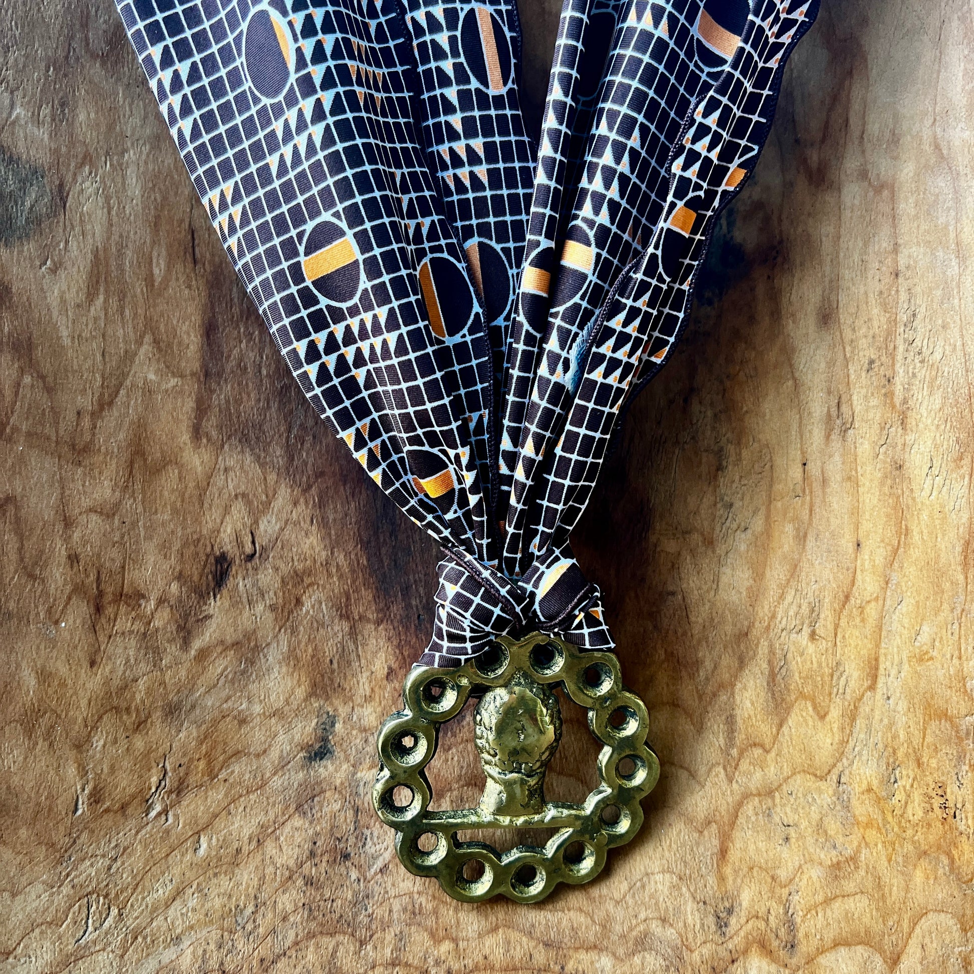 Decorative ribbon with a brass medal on a wooden surface