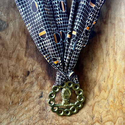 Decorative ribbon with a brass medal on a wooden surface