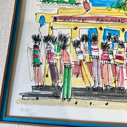 A framed hand-drawn illustration showing a group of people standing in front of a yellow municipal railroad station, with a blue frame border visible around the artwork.