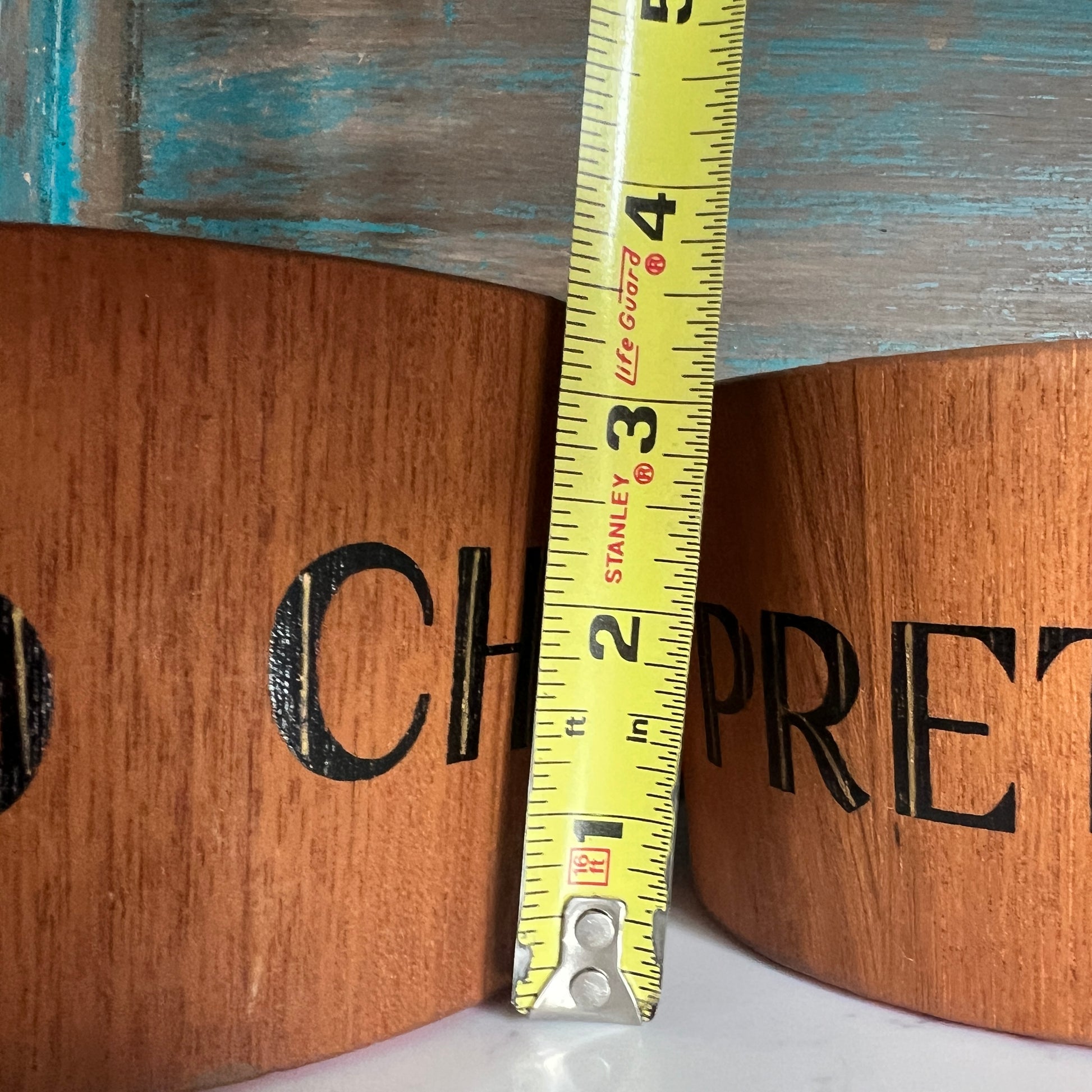 Wooden boxes with branding and a measuring tape indicating dimensions.