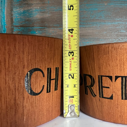 Wooden box with  branding and a measuring tape indicating dimensions.
