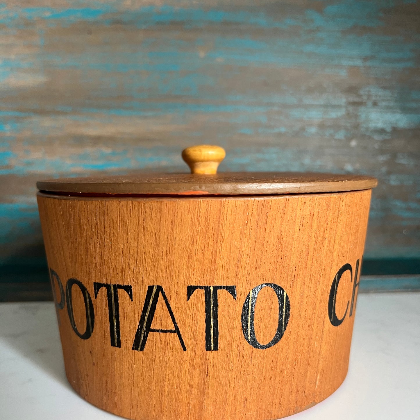 Wooden potato crock with a lid on a wooden surface