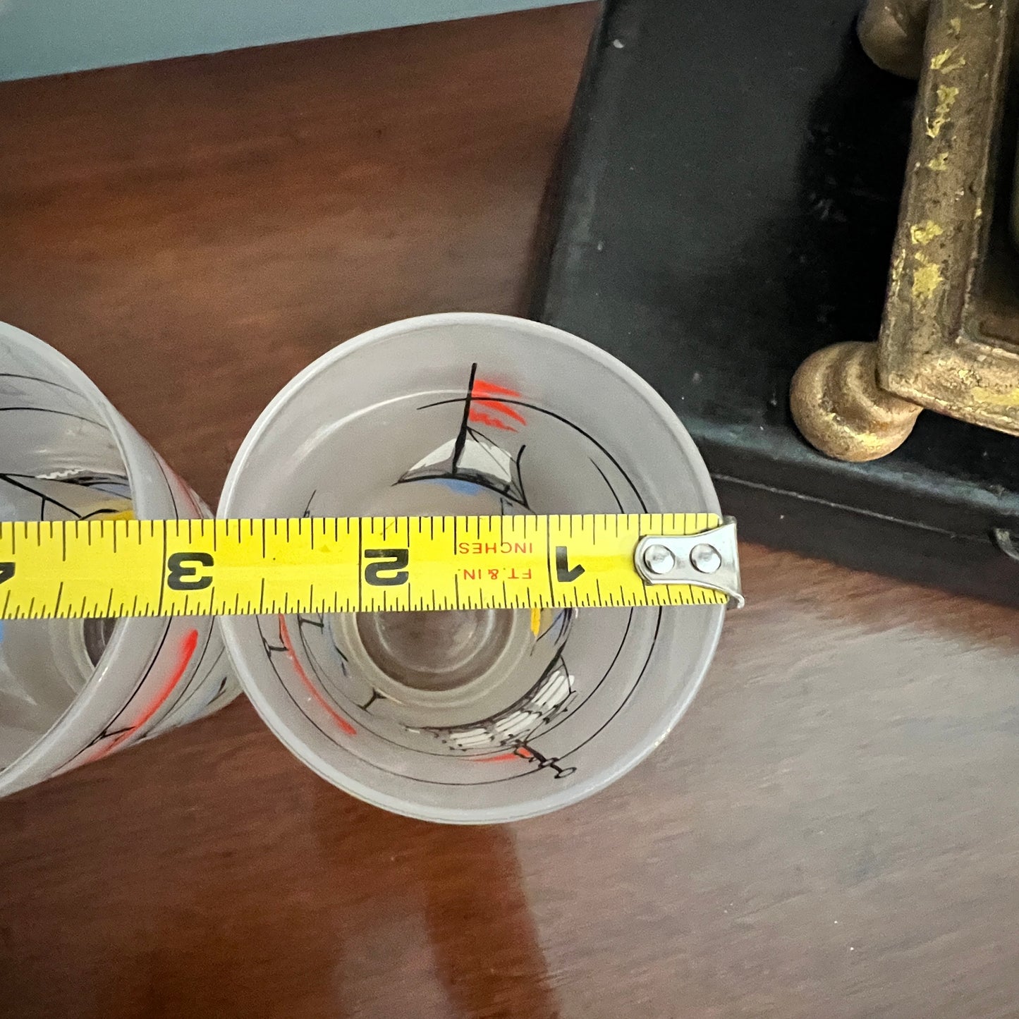Close-up of a reel with a measuring tape indicating dimensions on a wooden surface.