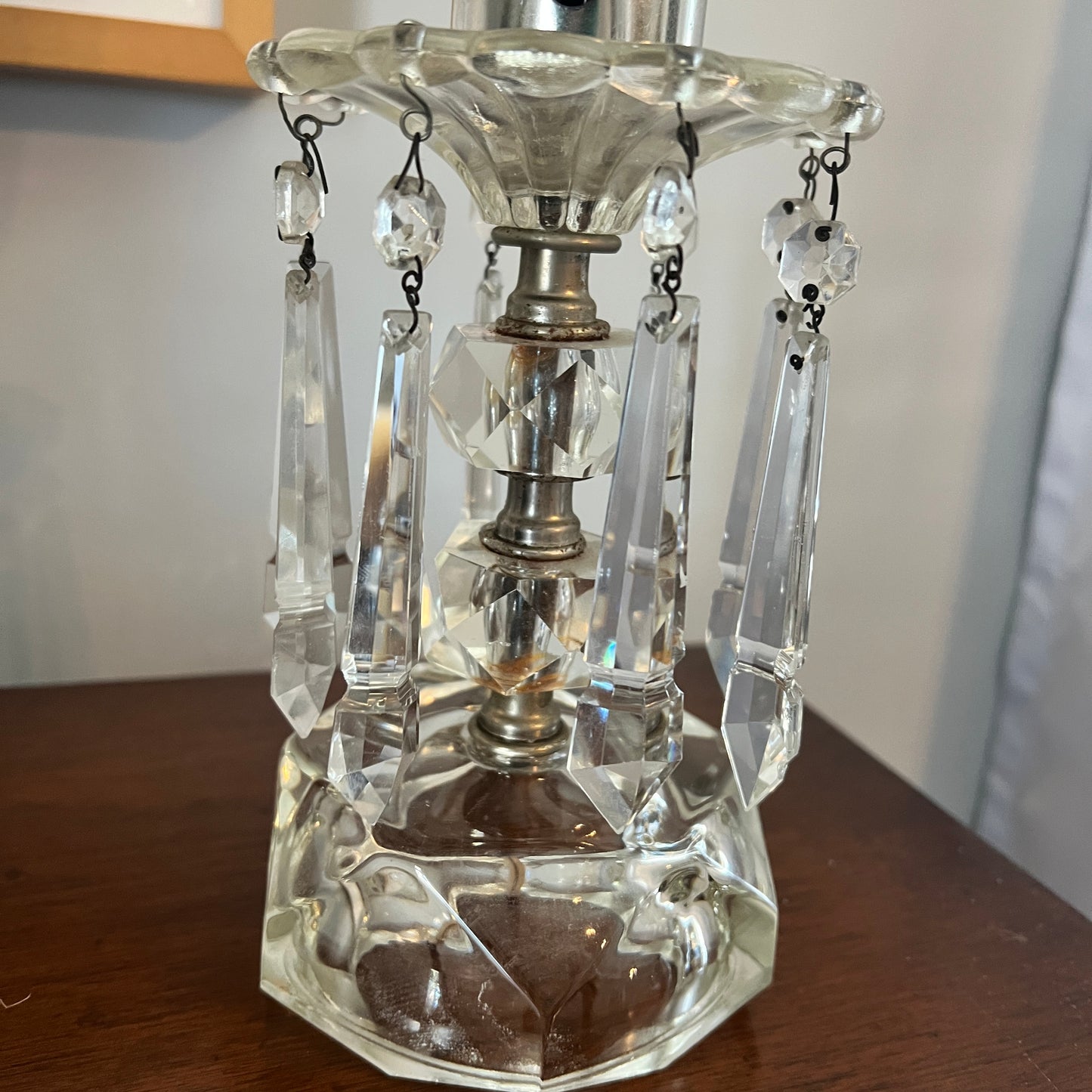 Clear glass lamp with crystal accents on a wooden surface