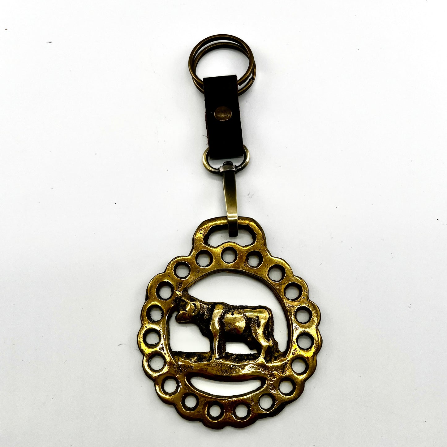 Brass keychain with decorative design on a white background