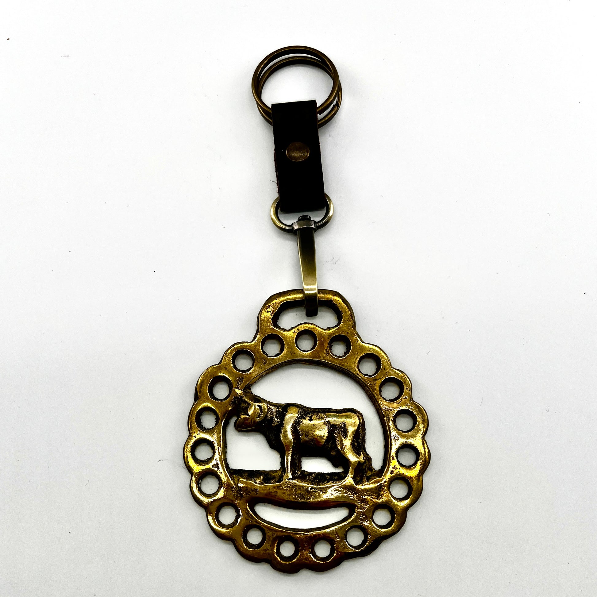 Brass keychain with decorative design on a white background