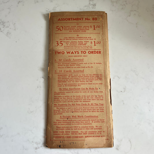 A vintage printed card assortment order form from 1954, showing 'ASSORTMENT No. 80' in red text on aged tan paper, photographed flat on a white marble surface.