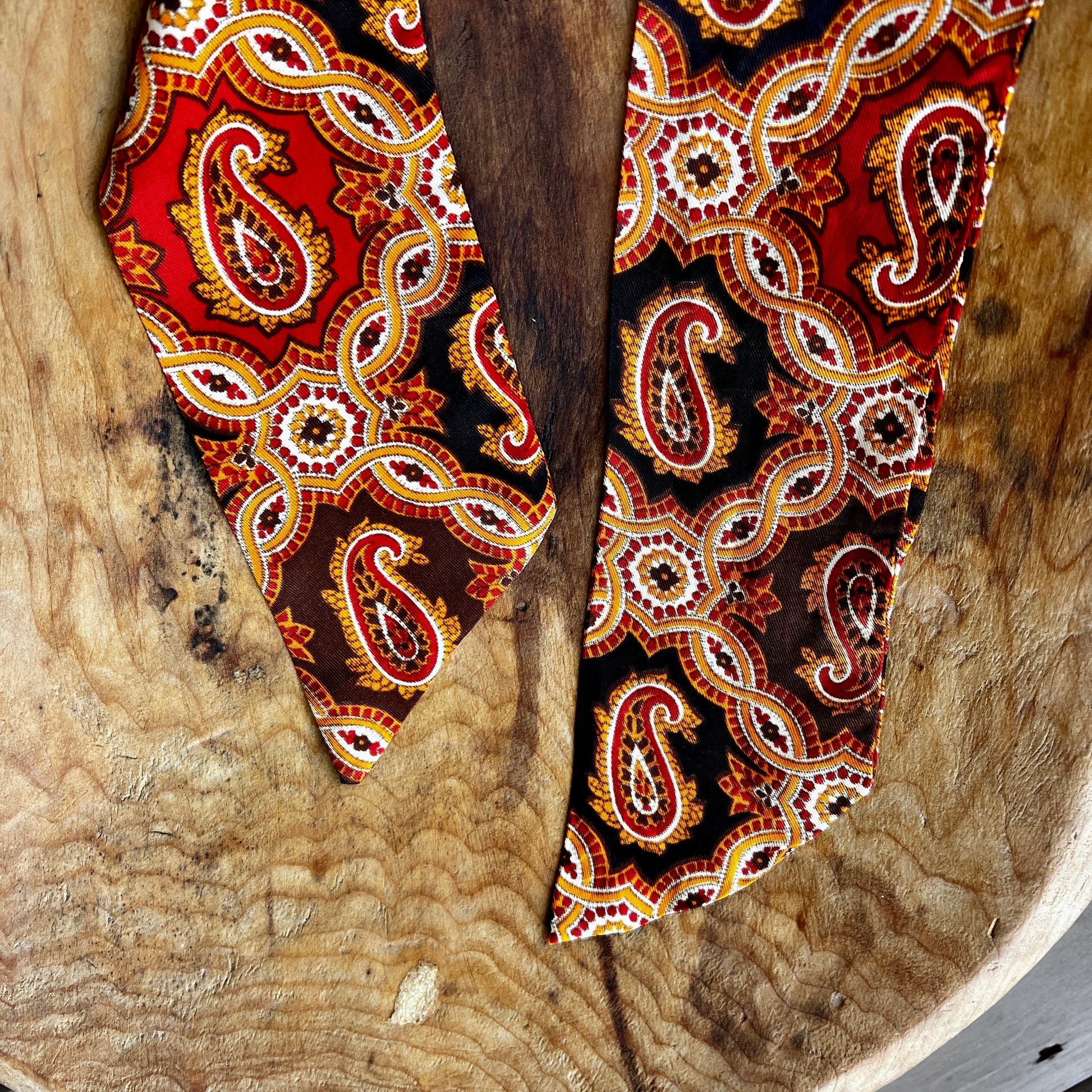decorative wooden pieces with intricate paisley patterns on a rustic wooden surface.