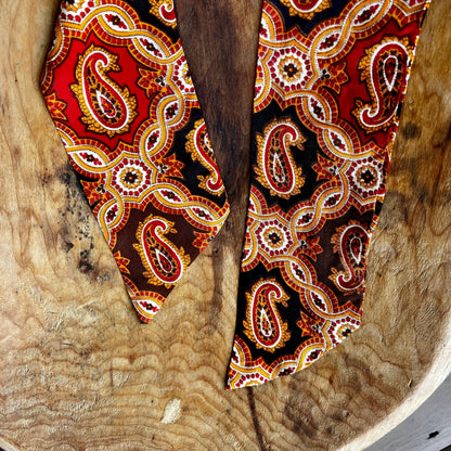 decorative wooden pieces with intricate paisley patterns on a rustic wooden surface.