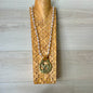 Necklace with a gold pendant on a wooden stand against a wooden background
