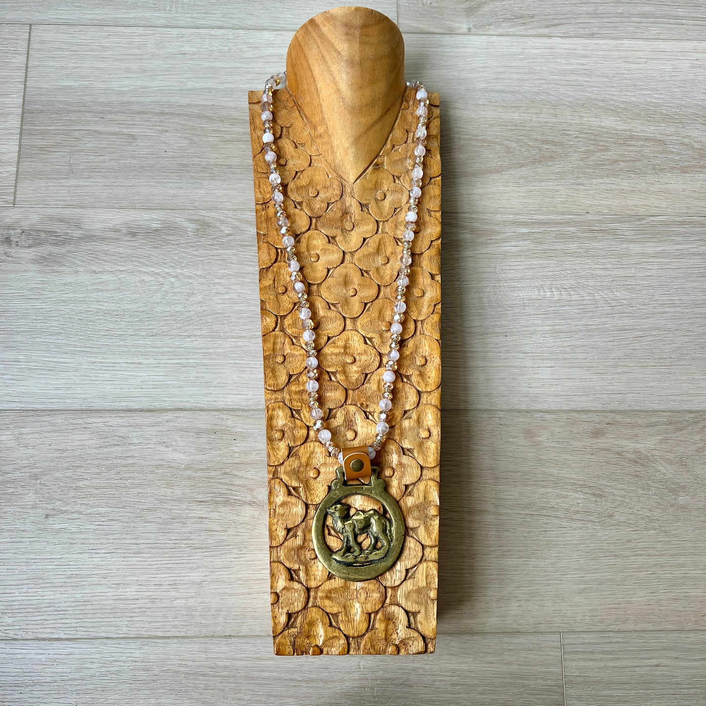 jewelry stand with a necklace on a wooden surface