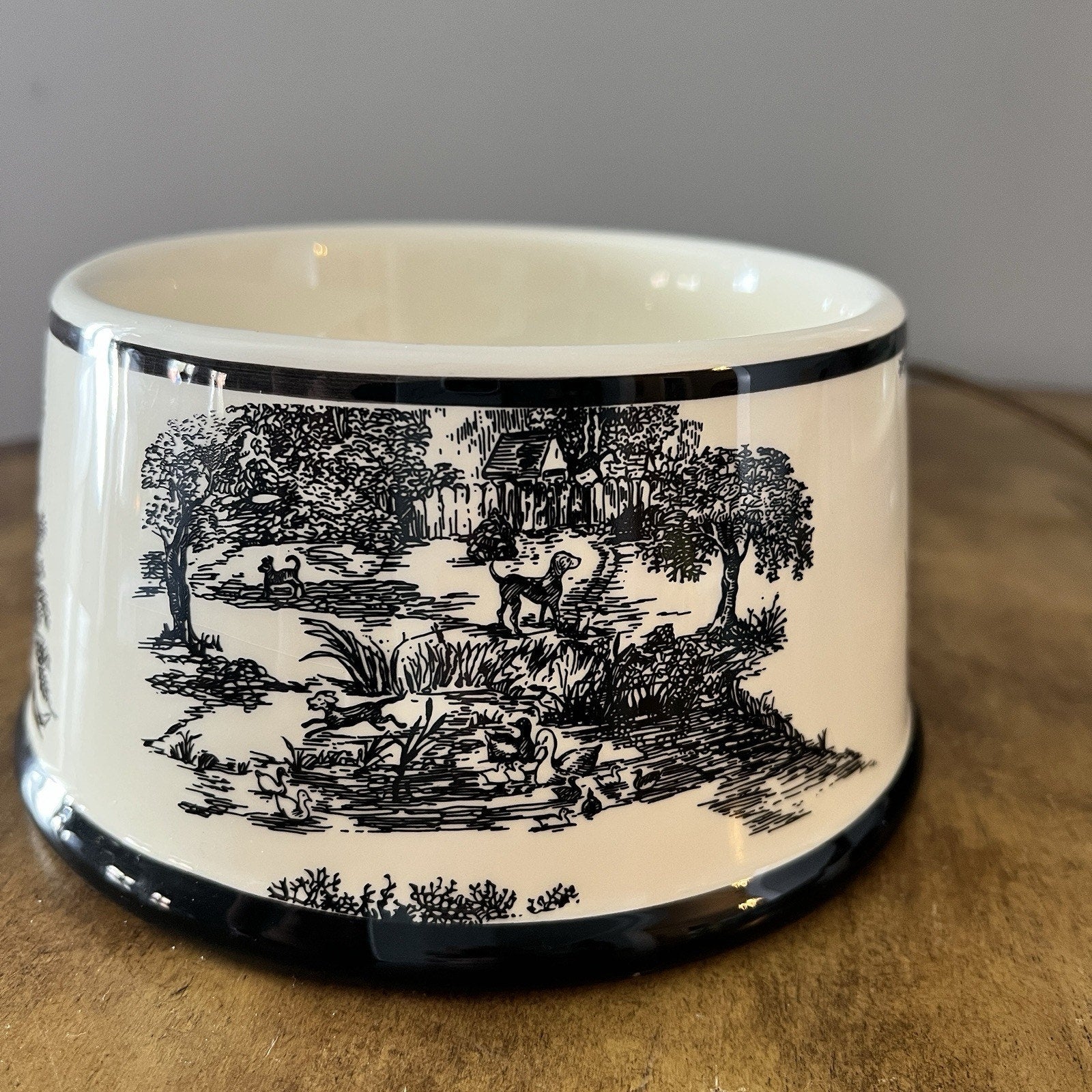 White ceramic bowl with black landscape design on a wooden surface