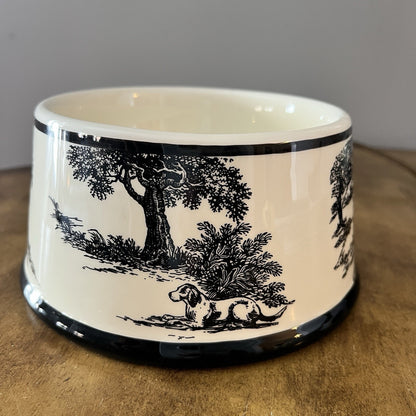 Ceramic bowl with black animal illustration on a wooden surface