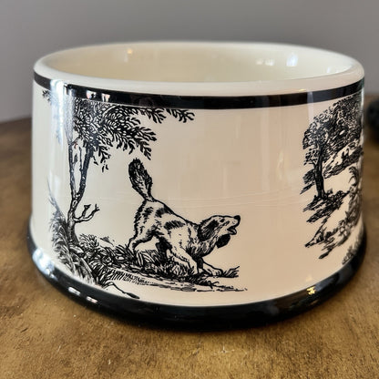 Ceramic bowl with black and white dog illustration on a wooden surface