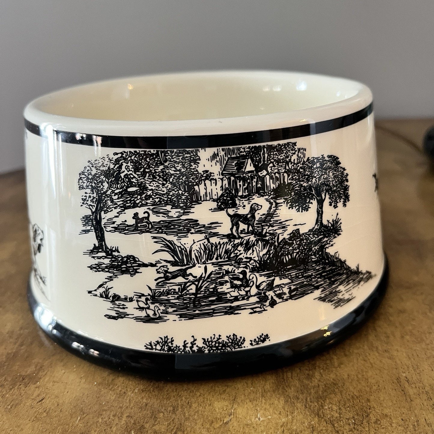 Ceramic bowl with black and white landscape design on a wooden surface