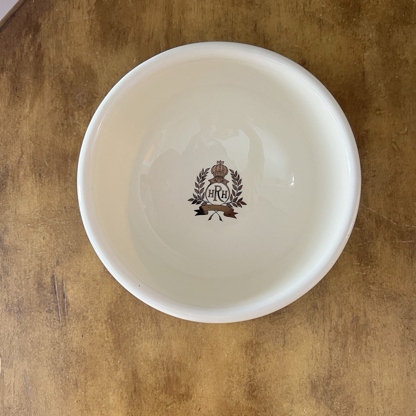 White bowl with a logo on a wooden surface
