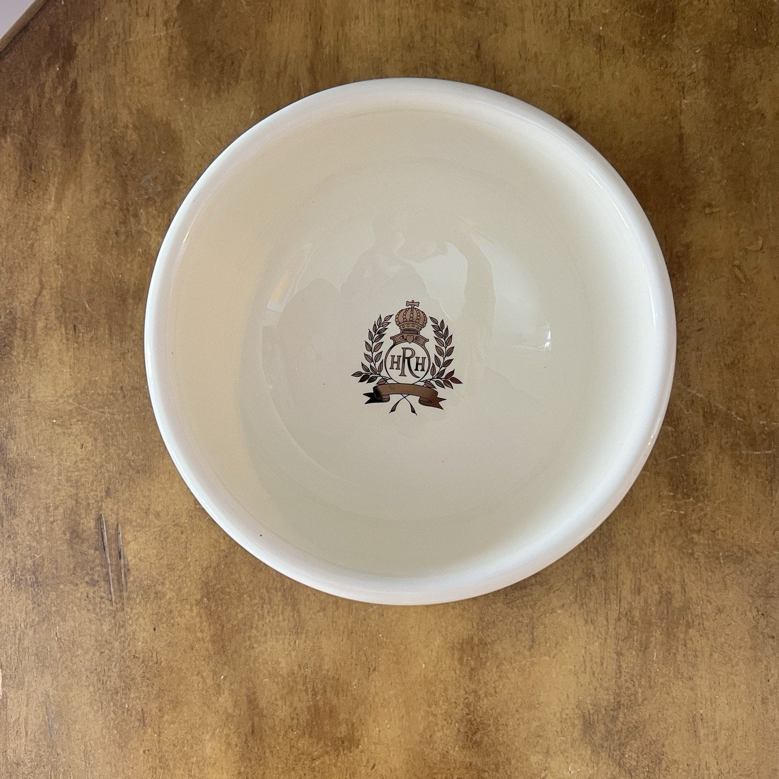 White bowl with a logo on a wooden surface