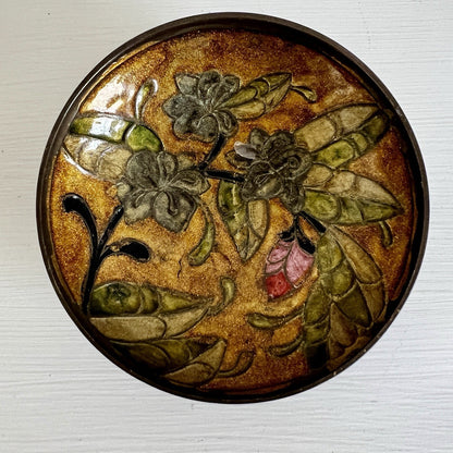 Decorative bowl with floral design on a textured surface